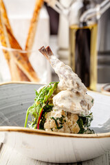 Creamy rabbit leg with cauliflower and greens