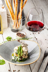 Creamy rabbit leg with vegetables and red wine