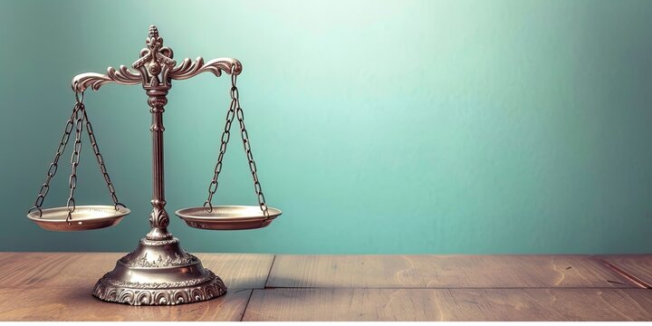 A balanced scale representing justice and law on an old wooden table with green background.