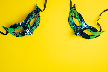Two Sequin Masquerade Masks on Bright Yellow Background. Copy space