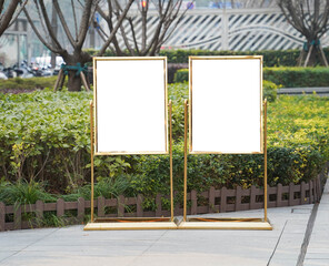 Double blank white outdoor advertising boards mock up template. Clear street signage board placed by an outdoor dinning area of a restaurant.