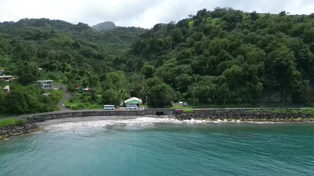 drone view of lush green mountains and small tropical bay in Grenada