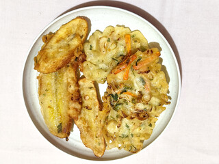 Gorengan, a traditional Indonesian street food consisting of fried bananas and bakwan (fried...