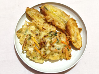 Gorengan, a traditional Indonesian street food consisting of fried bananas and bakwan (fried...