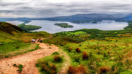 Hiking trail on Conic Hill overlooking Loch Lomond with panoramic landscape of Scottish Highlands