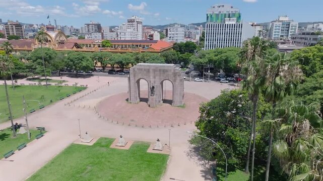Cinematic aerial drone orbit view of the Monumento ao Expedicionario arch in Farroupilha Park Redencao. Historic landmark in Porto Alegre Rio Grande do Sul. 4K ProRes 10-bit video.