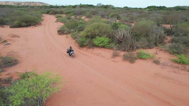Aerial Drone View of Motorcyclist Crossing Desert in Araya Venezuela