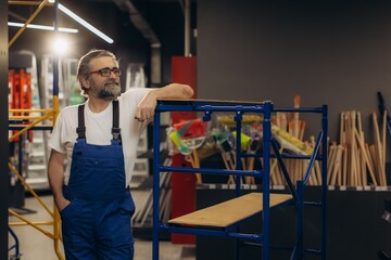 Worker posing in hardware store with scaffolding