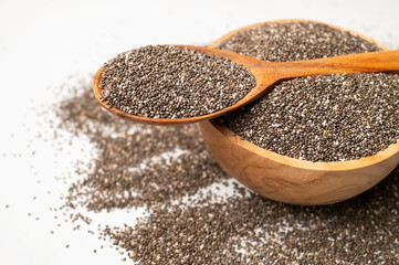 Close-up of chia seeds in wooden spoon and a bowl. Superfood, organic, healthy dry seeds for meals, breakfast, and desserts. Rich in omega-3, protein and protein. Food background