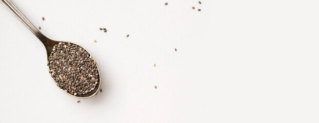 Dry chia seeds in an aged metal spoon on white background. Organic, healthy chia seeds, rich in omega-3, protein, and vitamins. Superfood, food background with space for text
