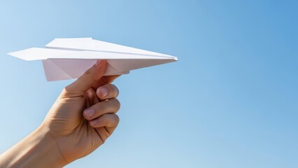 Hand Ready to Launch Paper Airplane into Blue Sky