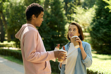 Naklejka premium Loving couple shares smiles and drinks in a serene park setting on a sunny day