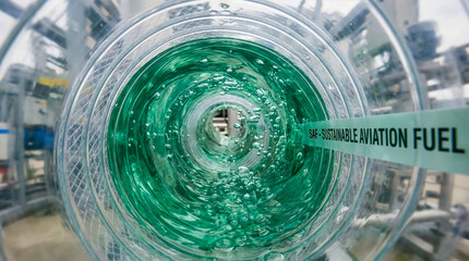 POV inside transparent industrial fuel pipe with green sustainable aviation fuel SAF, microbubbles - saf focus