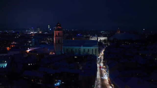  Aerial view of downtown Vilnius at night with illuminated streets .