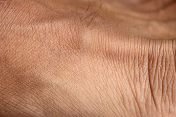 Fototapeta premium The texture of the skin on men's feet is brown with a wrinkled pattern