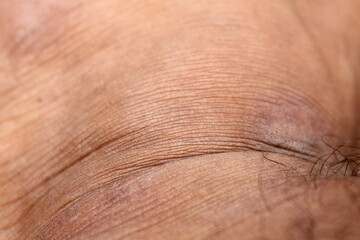 Fototapeta premium The texture of the skin on men's feet is brown with a wrinkled pattern