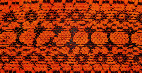 Real genuine python snake skin as background, exotic animals. Natural snake skin pattern, red color.