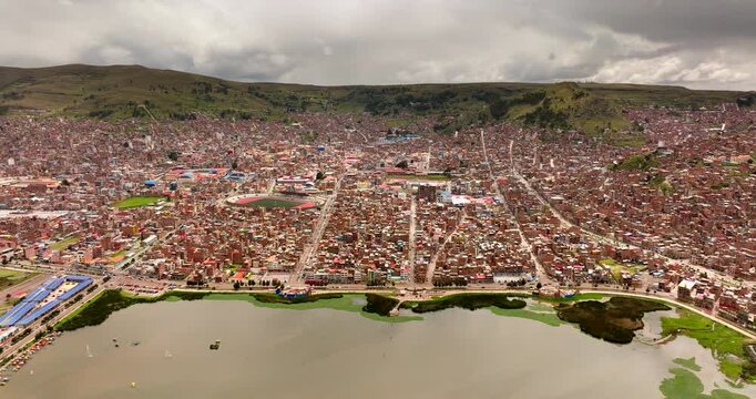 Populous and dense construction of Puno city on Lake Titicaca, drone establisher