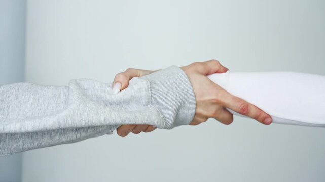A handshake between two people.
A man and a woman cling to each other and don't let go.
Mutual help and support.
Fear of separation.