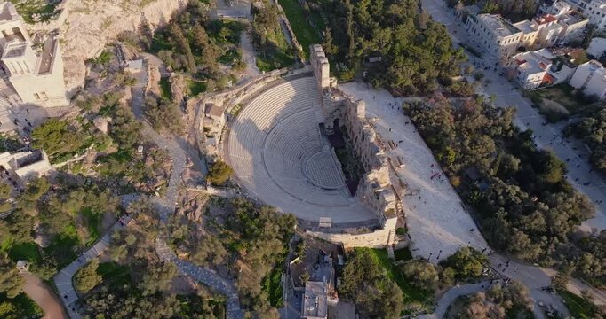 Cinematic bird&rsquo;s-eye drone view of the Theatre of Dionysus Eleuthereus at sunset in Athens, Greece. Ancient stone ruins, warm golden light, and historic atmosphere ideal for travel, culture, etc.