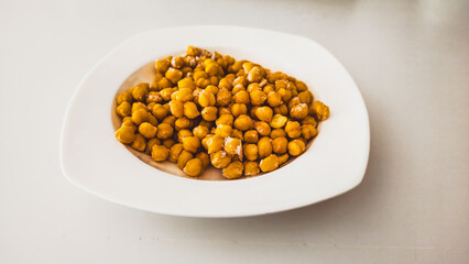 Frozen chickpeas in a white bowl on a white background