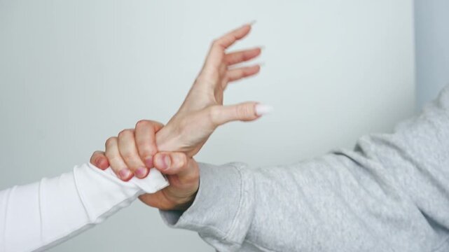 Domestic violence and abusive relationships.
A woman defends herself from a man's attack.
Hands fighting against a white background.
Struggle and conflict