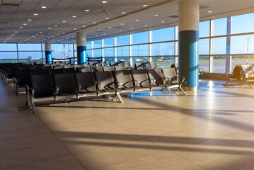 Empty waiting area with seats in a modern international airport terminal.