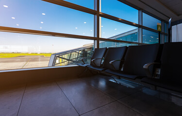 Airport waiting area with jet bridge window view.