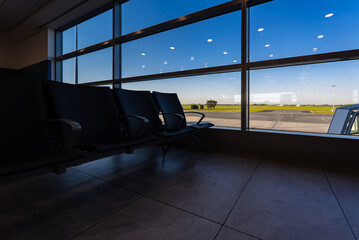 Empty waiting area with seats in a modern international airport terminal.