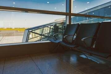 Airport waiting area with jet bridge window view.