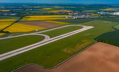 Aerial view of an airport runway among green fields.