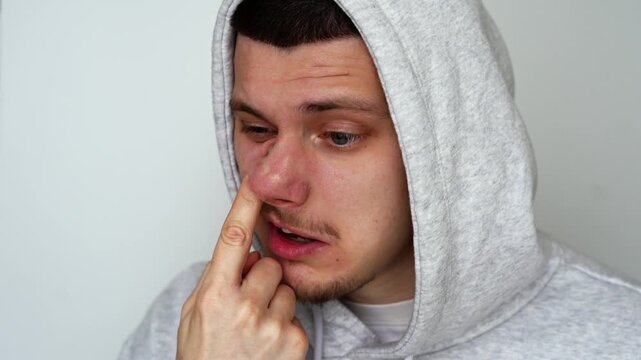 A man stuck his finger up his nose and was picking at it with his index finger.
An uncultured man stuck his finger up his nostril.