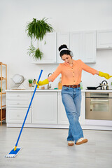 Young woman enjoying spring cleaning while dancing in her modern apartment