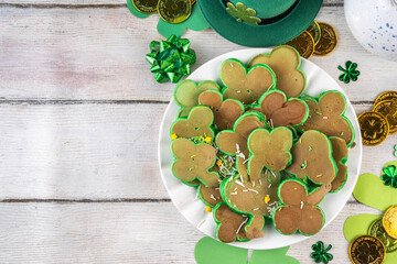 Shamrock shaped green tasty sweet pancakes for St Patricks day breakfast. Creative homemade tasty fried pan cakes with sugar sprinkles and Saint Patrick holiday decor