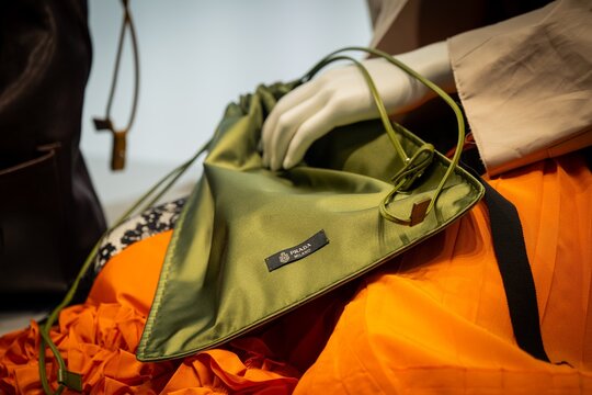 Milan, Italy - 2026, 13 Jan: Prada FW25 green clutch and orange skirt create a bold, modern statement with luxury textures and innovative Italian design