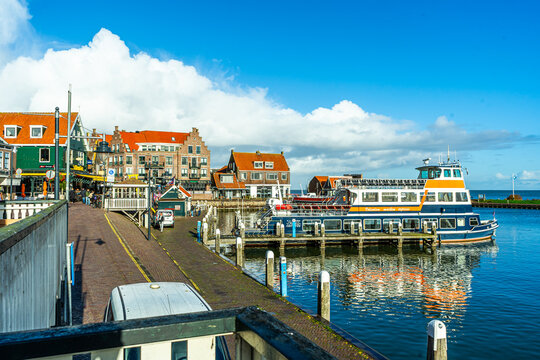 Volendam, Netherlands - October 27, 2025: Marken Boat Tour ship on embankment. Old Dutch port building architecture. Holland harbor express