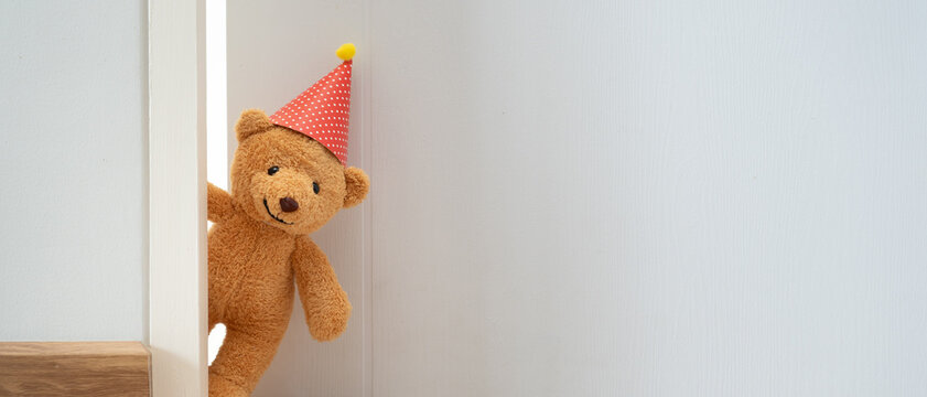 Teddy bear playing hide and seek behind the door, Adorable child having fun in the home. happy family have fun with kids, activity, learning, activity, game, meditation