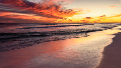 Obraz premium Soft Waves with a Warm Dramatic Sunset