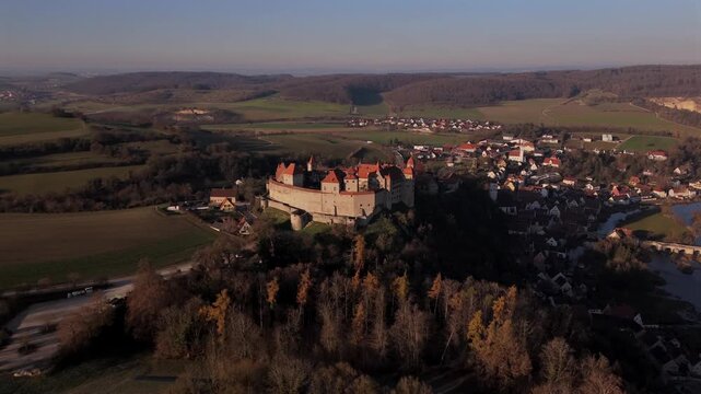 Scenic aerial view of Burg Harburg in Noerdlinger Ries, Bavaria, Germany showing the historic hilltop castle above the Woernitz River during a sunny spring sunset.