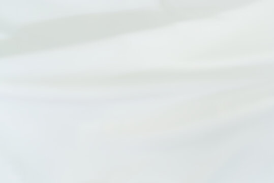 The bright white satin fabric texture is wavy and beautiful and luxurious. For background and backdrop.