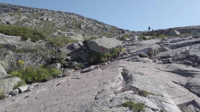 Norway. Hiking to Trolltunga. First-person summer hike to Trolltunga near Odda, Norway. Sunny weather, crowded trail, and stunning high-mountain scenery with many tourists on the popular route