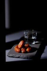 Dramatic Side-Lit Dates and Water for Iftar, Ramadan Kareem Tradition, Jumma Mubarak Blessings, Minimalist Fast-Breaking Meal