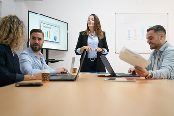 Business professionals collaborating and discussing results in office meeting