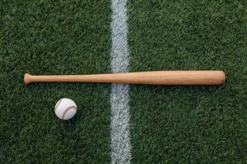 Wooden baseball bat and ball on green grass field