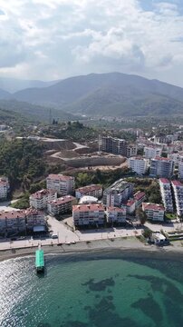 Cinematic footage of the sea with residential buildings along the coastline, showcasing modern urban living near the water. Calm waves, coastal cityscape, and waterfront apartments in a peaceful atmos