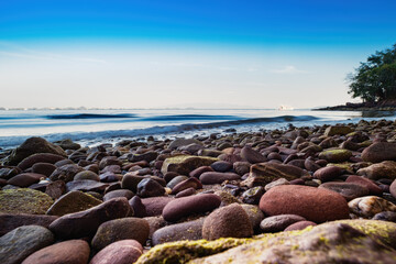 Close-up of smooth stone beach ocean background.