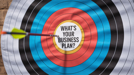 Archery target bullseye with arrow hitting center and "WHAT'S YOUR BUSINESS PLAN?" text concept for strategy