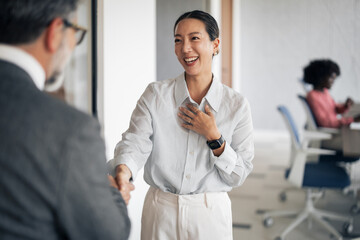 Businesswoman greeting coworker with a handshake in office © Jelena
