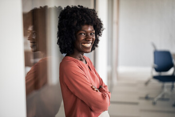 Confident Black businesswoman smiling in modern office interior