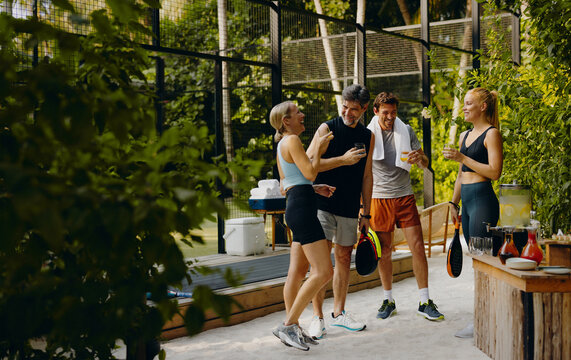 Family enjoying drinks after a fun padel game